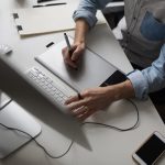 young-male-designer-using-graphics-tablet-while-working-with-com_158595-1133